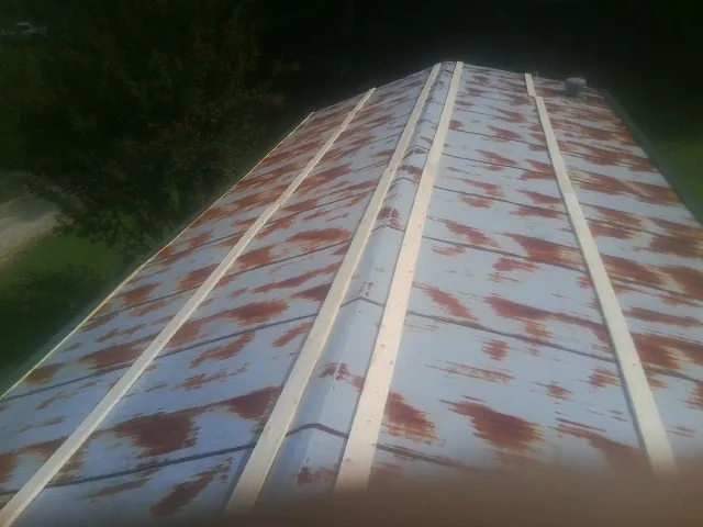 Rusted metal roof panels with new wood purlins before replacement — Storm Damage Roof Repair in Burgaw by Roofing Brothers