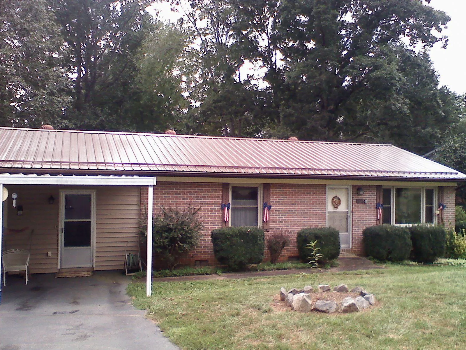 Bronze metal roof and carport on a brick ranch home — Roof Repair work by our crew in Burgaw